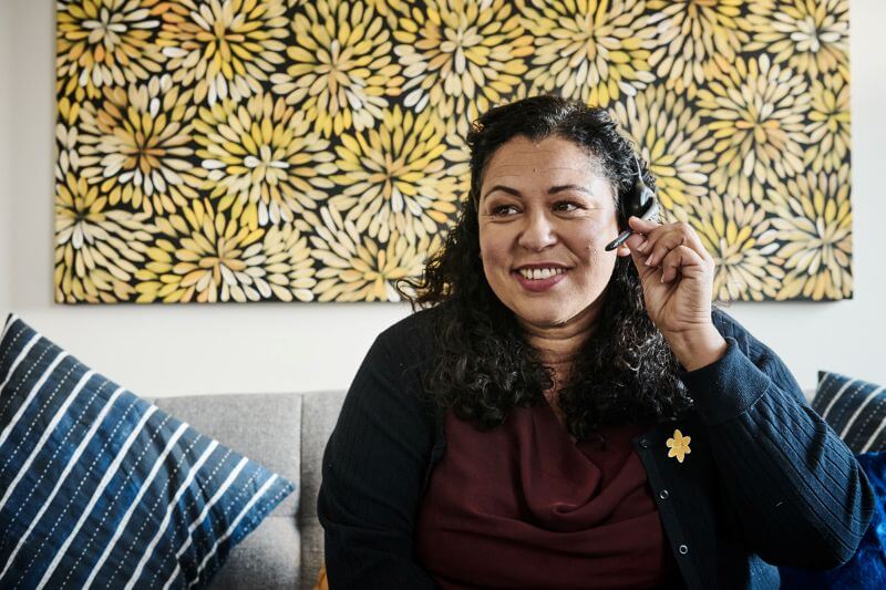 A Cancer Connect staff member smiles while wearing a headset 