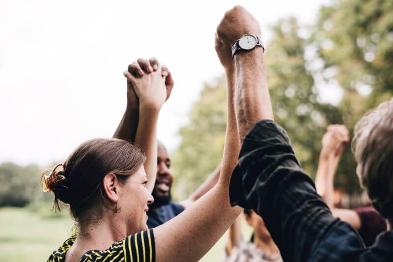 A group of people in circle, holding hands