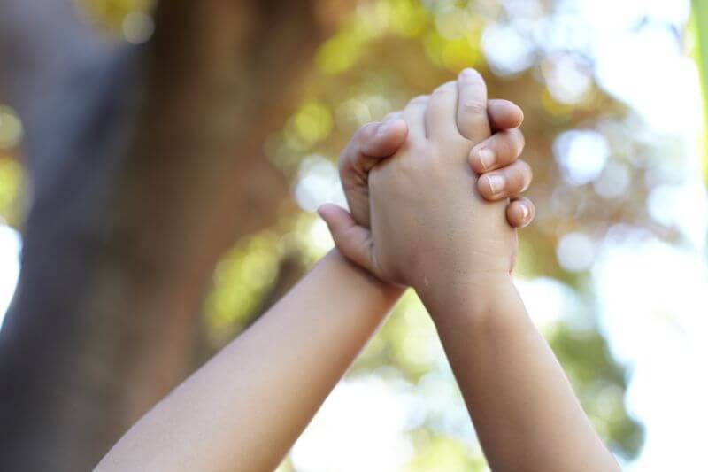 Two people holding hands raised in the air.