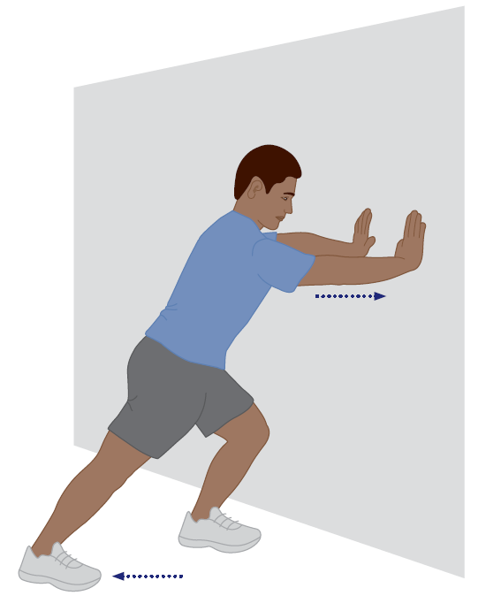 Illustration of a standing calf stretch performed against a wall. A person leans forward with both hands placed on the wall at shoulder height. One leg is positioned forward with a bent knee, while the other leg extends straight behind with the heel on the floor. Blue arrows indicate pressing the body forward toward the wall and extending the back leg behind to stretch the calf muscles.