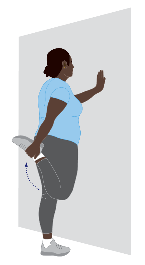 Illustration of a standing quadriceps stretch performed beside a wall for support. A person stands on one leg with one hand pressed against the wall and the opposite hand holding the ankle of the bent leg behind the body. The heel is drawn toward the buttock to stretch the front of the thigh. A curved blue arrow indicates the upward movement of the foot toward the body.